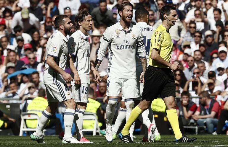 Los jugadores del Real Madrid protestan una jugada a De Burgos Bengoetxea.