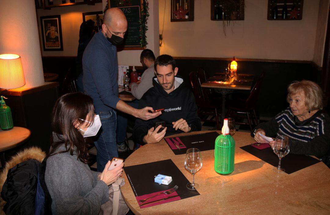 Un restaurador demanant comprovant el passaport covid en un bar de Gràcia