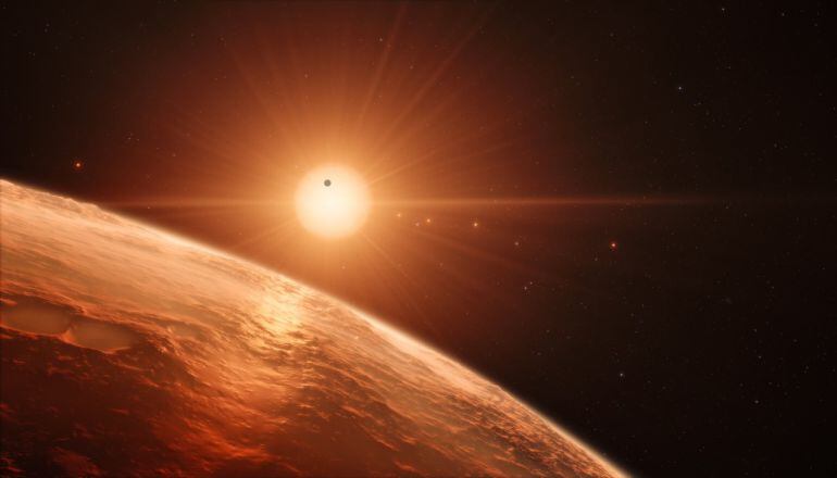 Recreación artística desde la superficie de uno de los exoplanetas del sistema TRAPPIST-1, un sistema de siete planetas que orbitan esta estrella enana ultrafría situada a una distancia de sólo 40 años luz de la Tierra .