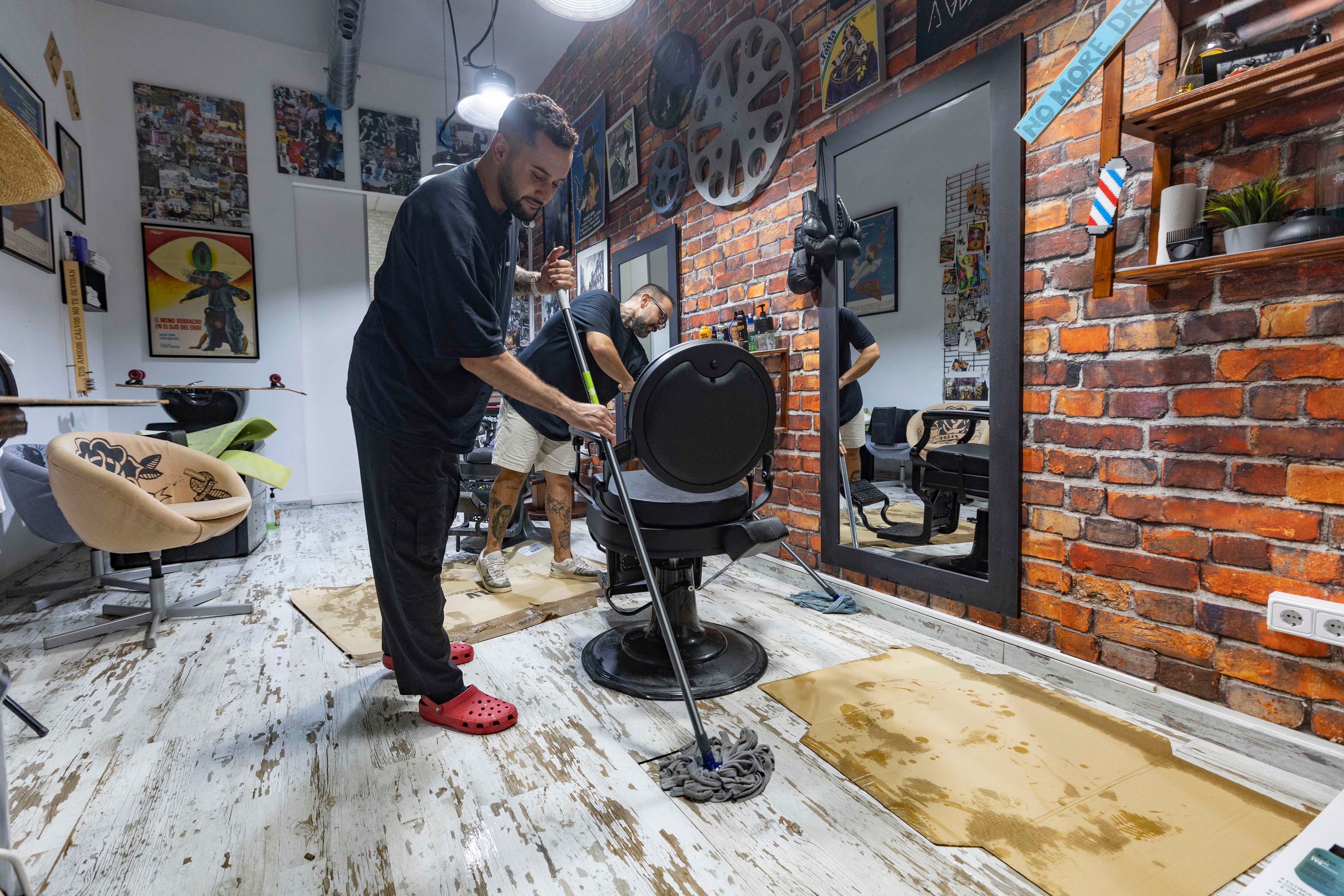 MOLINA DE SEGURA (MURCIA), 29/09/2025.- Dos hombres retiran el agua que ha inundado su peluquería tras las intensas lluvias caídas este lunes en Molina de Segura. Una tromba de agua de 73 litros por metro cuadrado (l/m2) ha obligado en la tarde de este lunes a rescatar a personas atrapadas en cuatro coches inmovilizados por el metro de altura que ha alcanzado el agua al final de la rambla por la calle San Juan y el Ayuntamiento de Molina de Segura (Murcia). EFE/Marcial Guillén