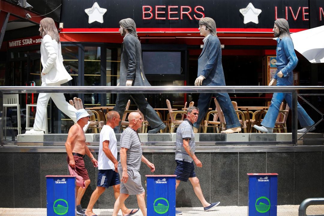 Un grupo de ingleses pasea por delante de un pub de Benidorm.