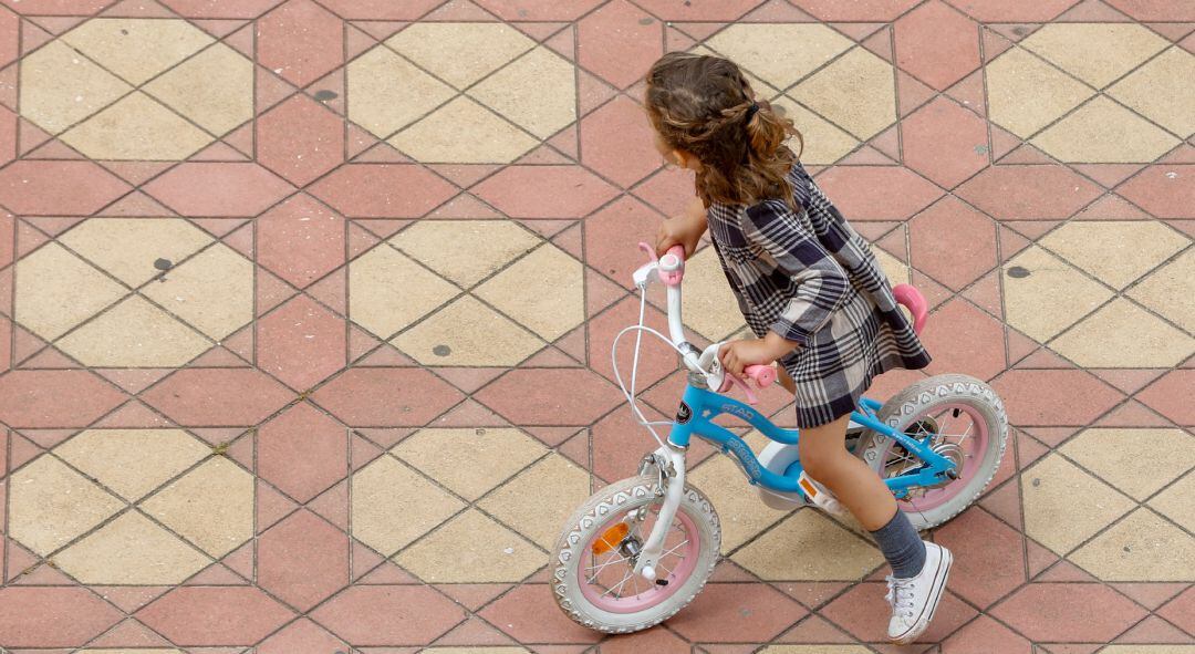 Una niña jugando con su bicicleta.