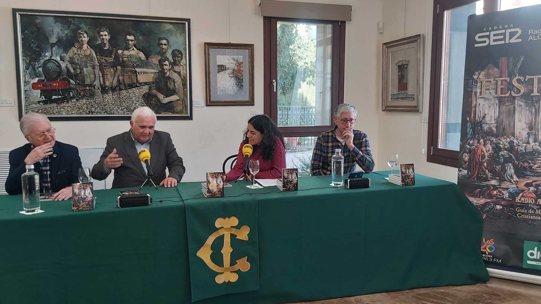 Paco Aznar, pintor del cuadro de la portada de Festa! 2025; Juan Jordá, director de Radio Alcoy, Maribel Vicedo y Gonzalo Belenguer, durante el programa emitido desde la sala Ramón Castañer del Círculo Industrial de Alcoy.