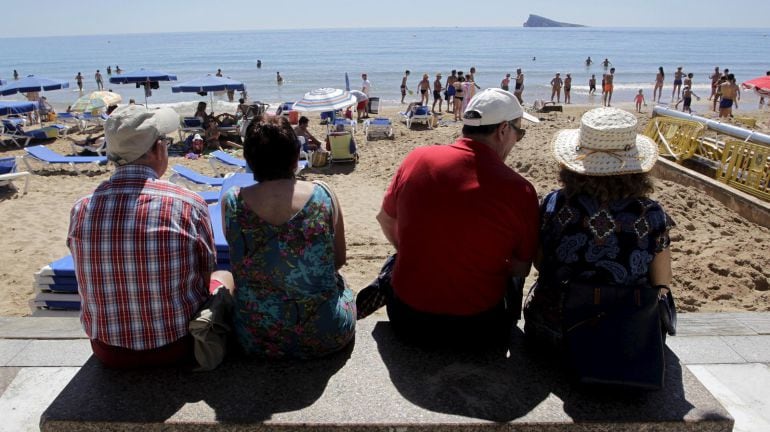 Varios turistas mayores disfrutan de la playa. 