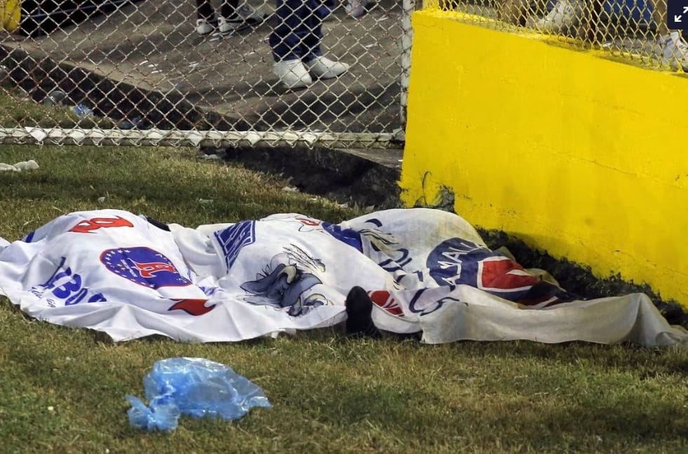 Una manta cubre varios cadáveres sobre el césped del Estadio Cuscatlán. / MILTON FLORES