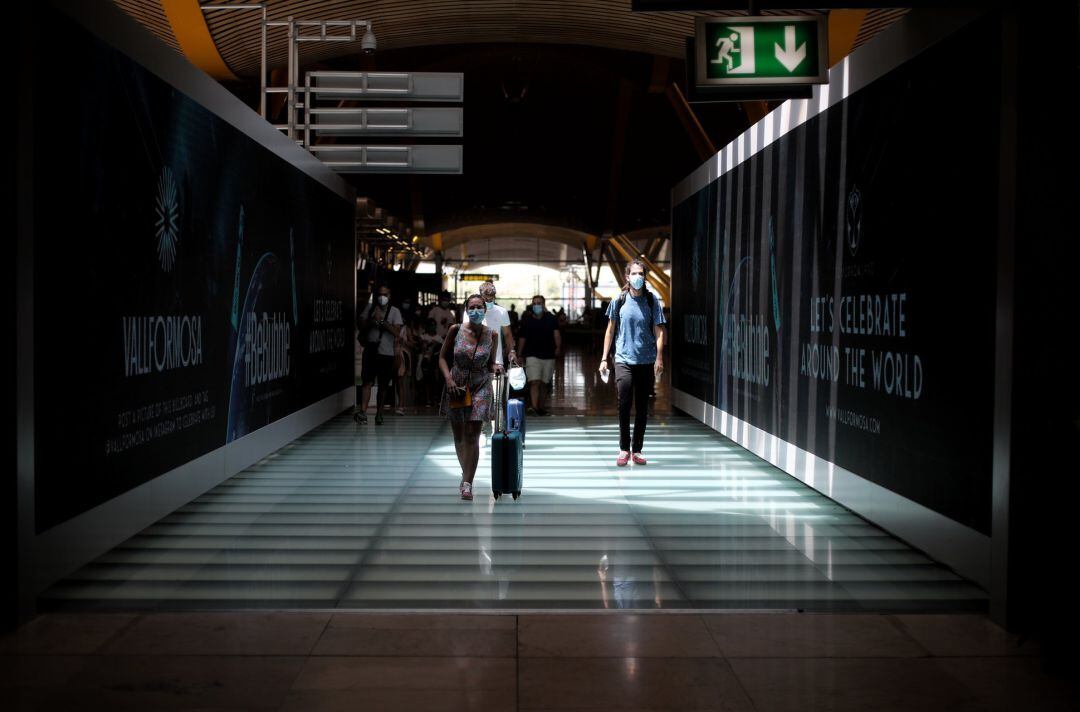 Pasajeros caminan en uno de los pasillos de la terminar T4 del Aeropuerto Adolfo Suárez Madrid Barajas, en Madrid (España), a 24 de julio de 2020. 