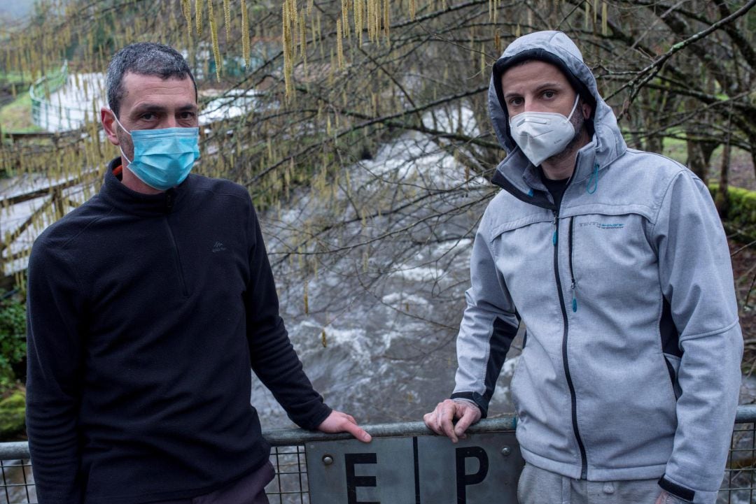 Dos vecinos de la localidad de Ponte Barxas (Padrenda) cruzan la pasarela sobre el río Troncoso que divide España y Portugal