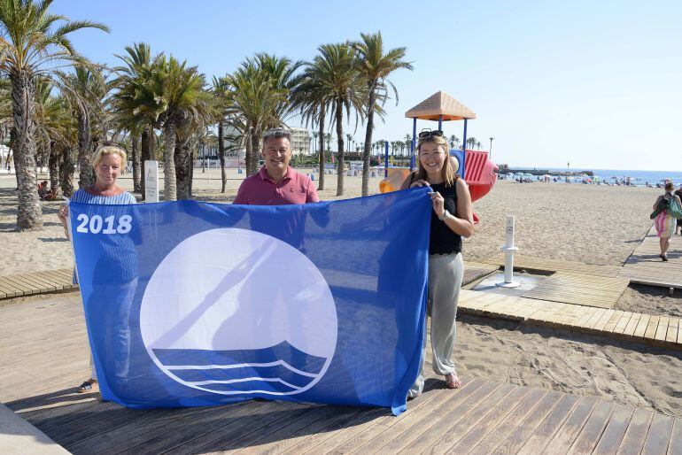 El alcalde José Chulvi y las concejales Doris Courcelles y Kika Mata, con la bandera azul del Arenal. 