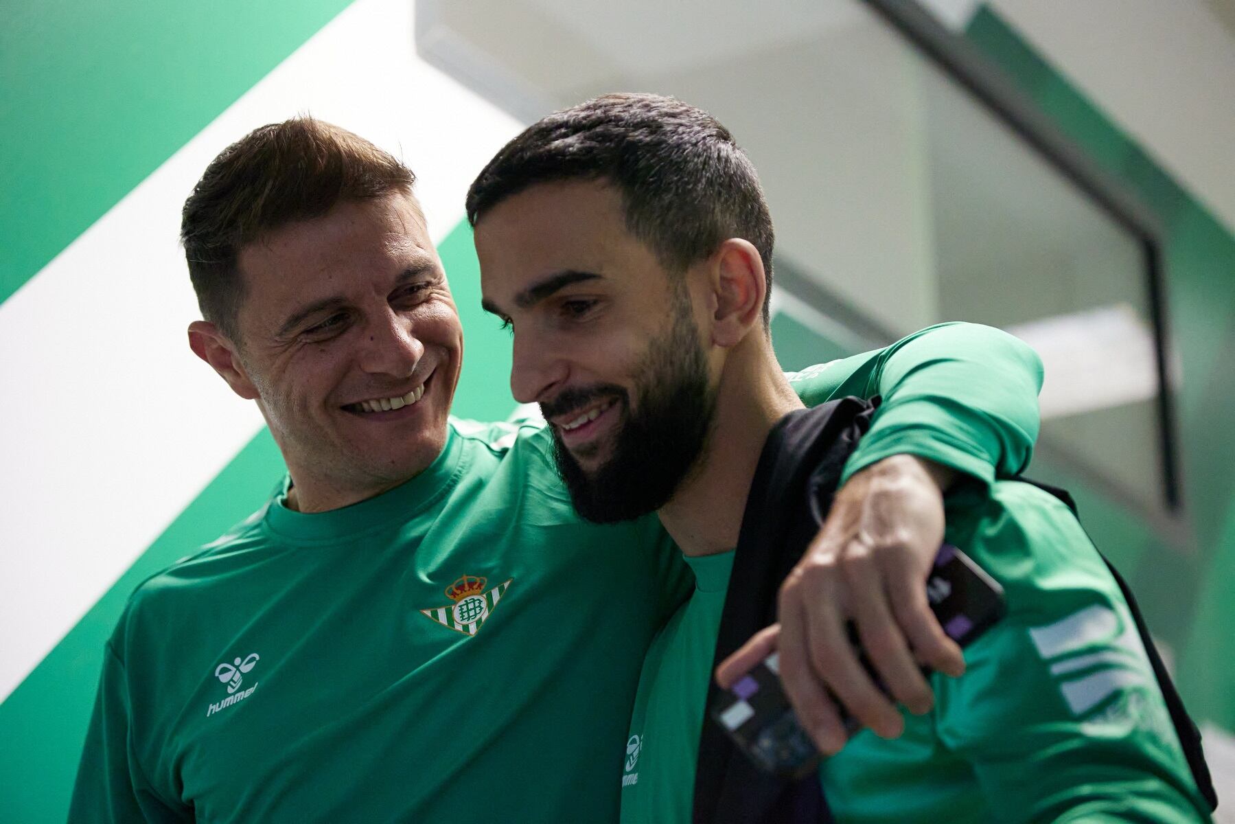El capitán del Betis, Joaquín Sánchez, dialoga sonriente con su compañero Martín Montoya el día de la vuelta al trabajo del equipo