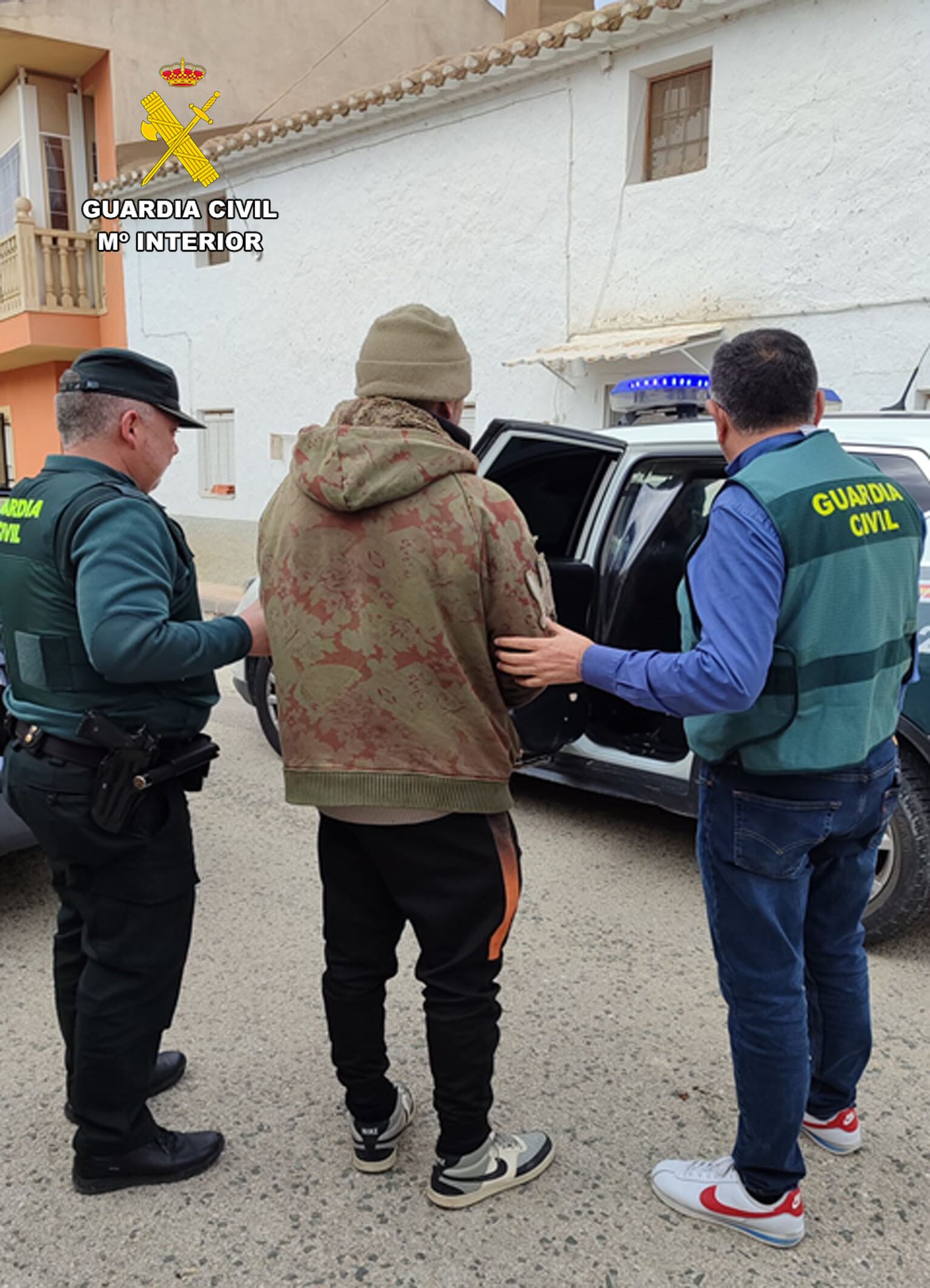 Uno de los detenidos es trasladado por agentes de la Guardia Civil