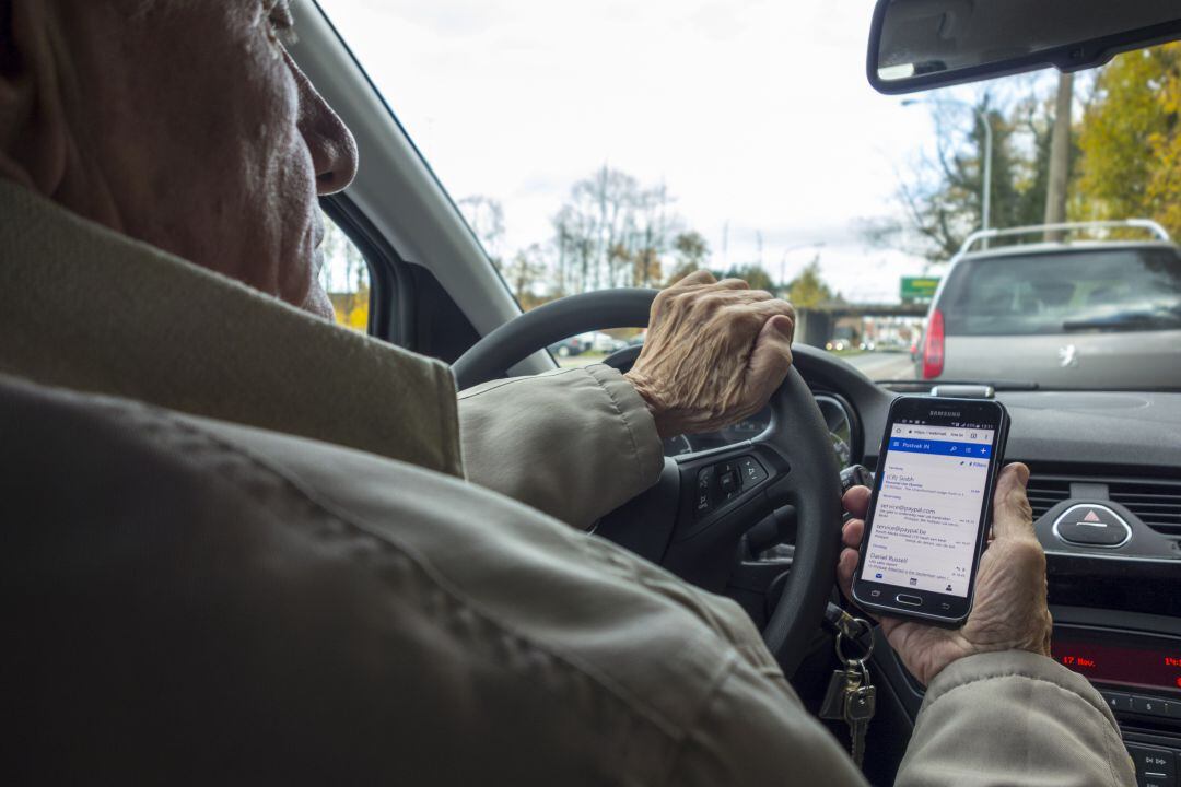 Imatge d&#039;arxiu d&#039;un conductor mirant el mòbil