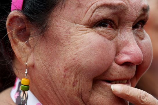 Detalle de una mujer emocionada junto a cientos de personas que se reúnen en la Plaza de Bolívar para observar la firma del nuevo acuerdo de paz