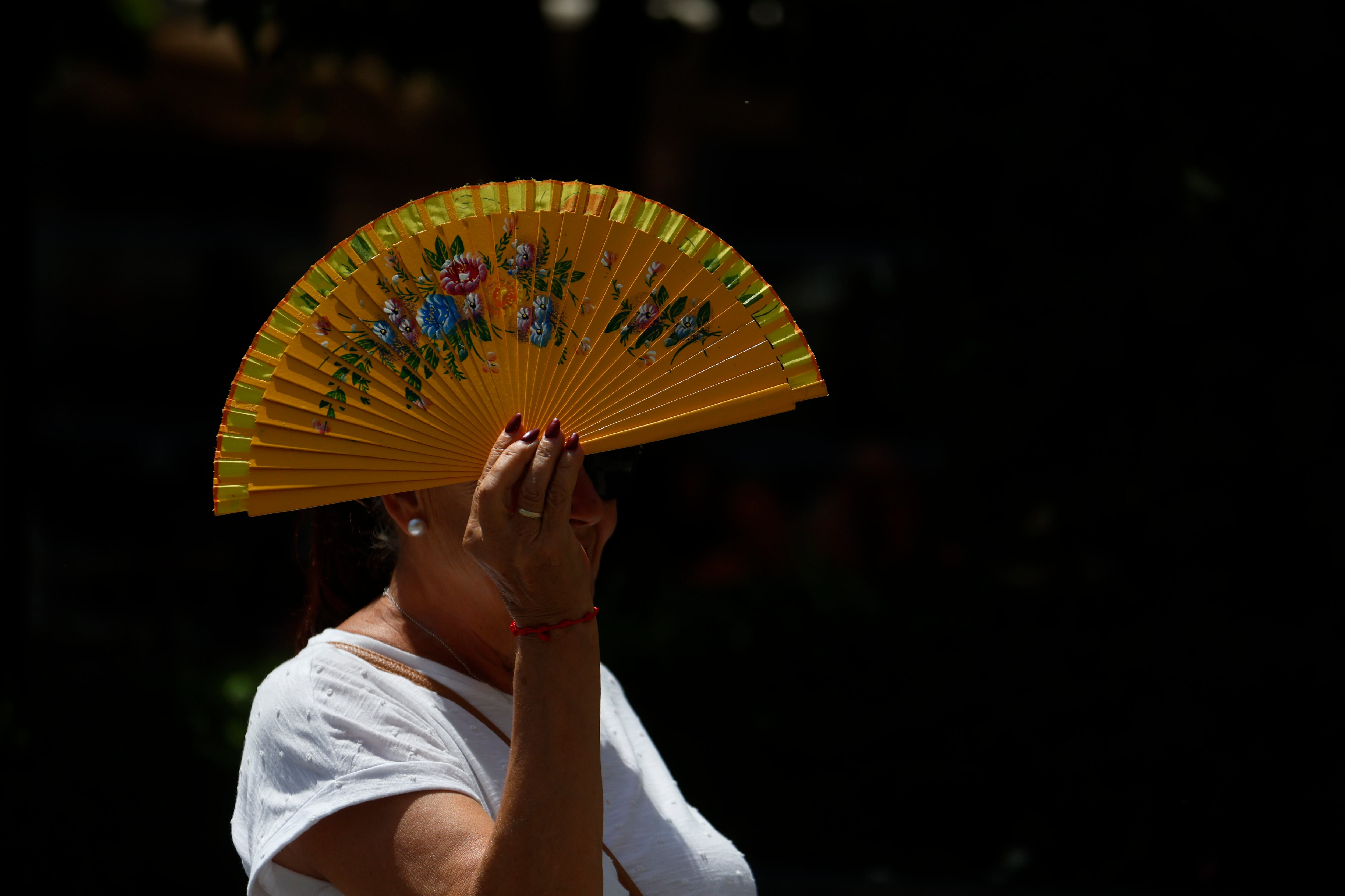 FOTODELDÍA GRAFAND9967. CÓRDOBA, 09/07/2025.-Una mujer se tapa con un abanico mientras camina por el centro histórico, este miércoles cuando se mantiene el aviso amarillo en Córdoba, donde se alcanzarán los 40 grados. Según los datos de la Agencia Estatal de Meteorología (Aemet) sitúan al valle del Guadalquivir, entre las provincias de Jaén y Córdoba, como la zona más calurosa del país puesto que no hay precedentes de que una comarca haya recibido durante 31 días consecutivos (en concreto desde el pasado 7 de junio) avisos por altas temperaturas. EFE/Salas

