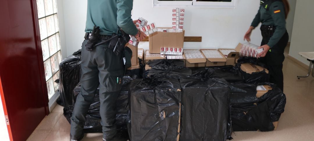 Agentes de la Guardia Civil con las cajetillas de tabaco interceptadas.