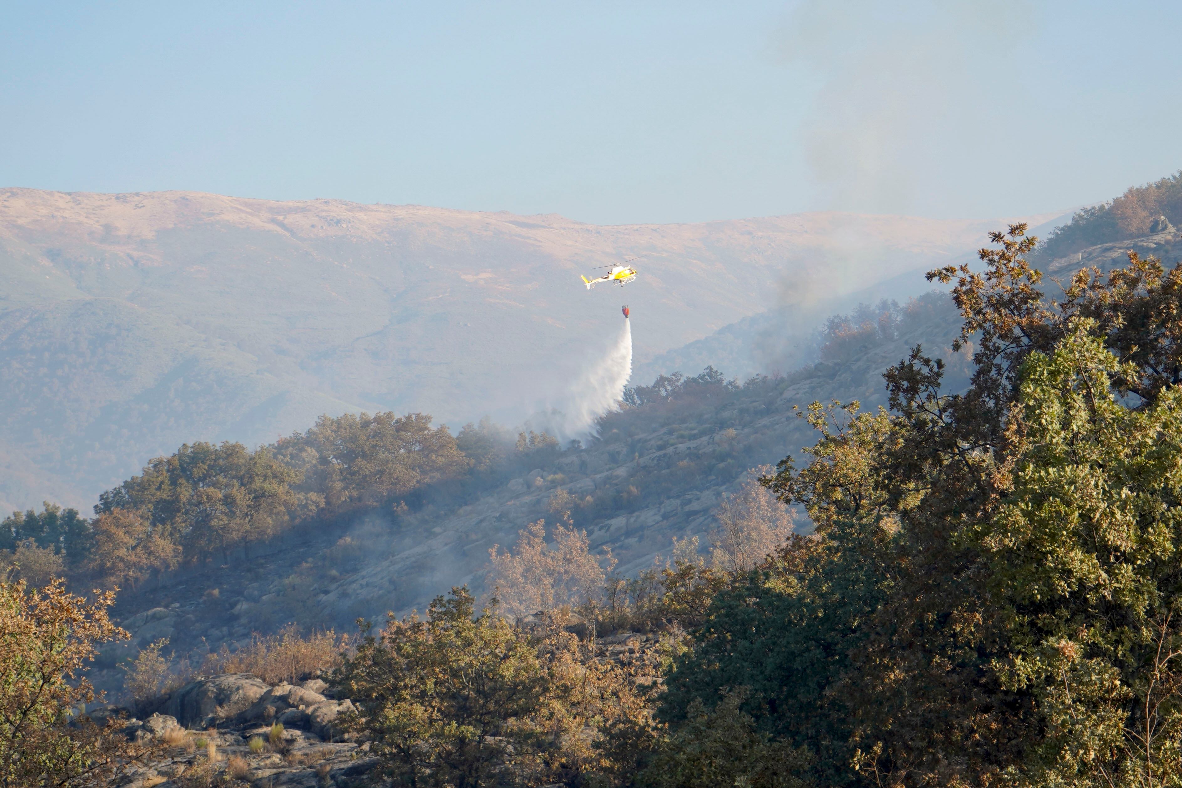 CUACOS DE YUSTE (CÁCERES), 22/09/2025.- Un helicóptero trabaja en las labores de extinción del incendio forestal declarado este domingo en Cuacos de Yuste (Cáceres), que ha arrasado 438 hectáreas de matorral y arbolado. EFE/  EDUARDO PALOMO
