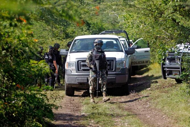 Varios agentes de seguridad custodian la zona de las fosas donde se han encontrados los cuerpos, en Iguala.