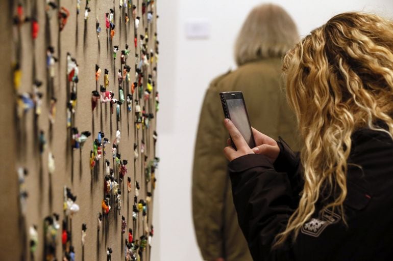 Una visitante fotografía una de las obras del artista valenciano Juan Genovés expuesta en la Feria Internacional de Arte (ARCO) 2016.