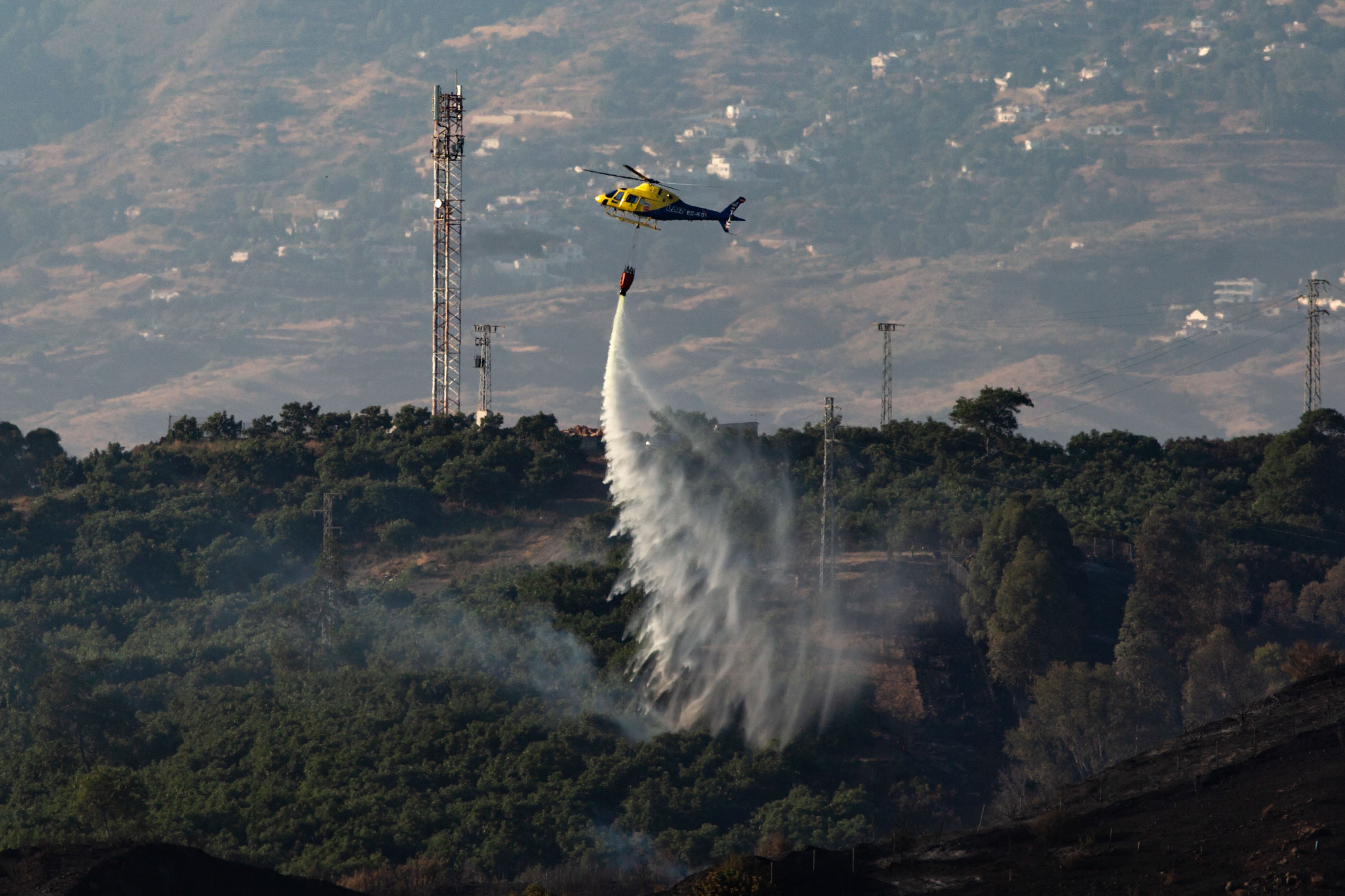 MIJAS (MÁLAGA), 26/07/2022.- Un helicóptero trabaja en las tareas de extinción del incendio declarado esta tarde en el paraje Majadilla del Muerto de la localidad malagueña de Mijas. EFE/Daniel Pérez
