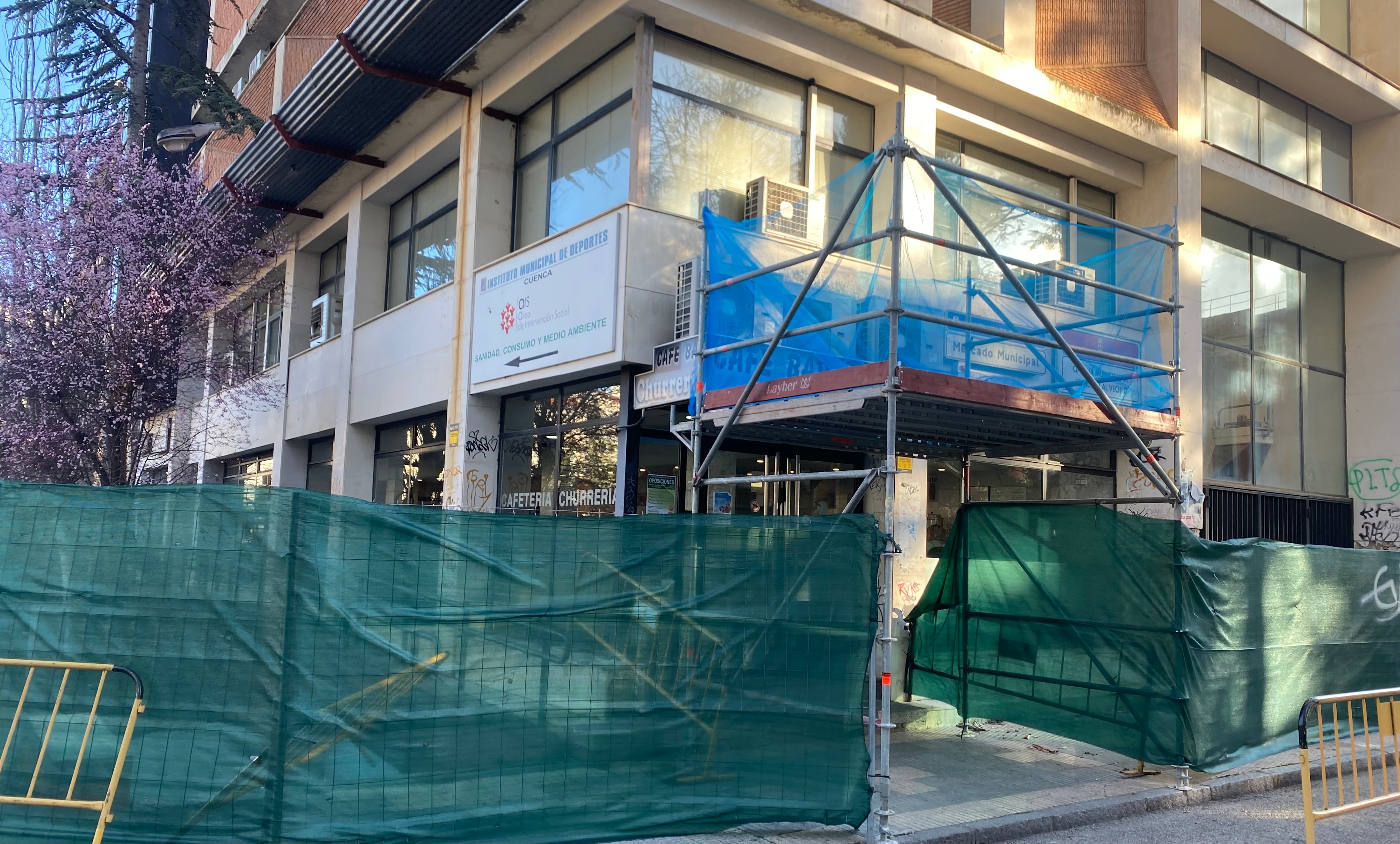 Edificio del Mercado de Cuenca rodeado de vallas con la churrería aún abierta en la esquina con la calle Gregorio Catalán Valero.