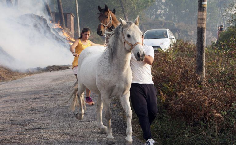 Vecinos de parroquia de Chandebrito, perteneciente al municipio pontevedrés de Nigrán, huyen de las llamas que se aproximan a sus viviendas