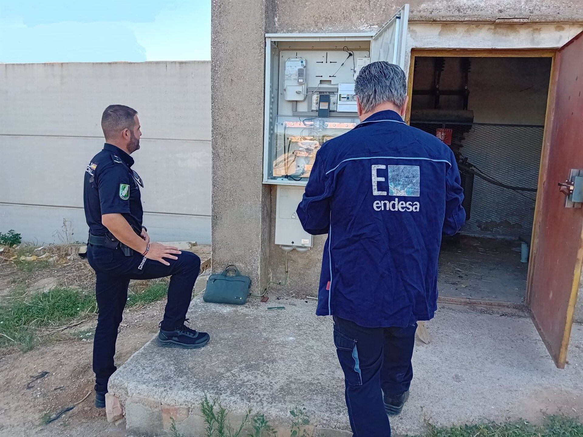 Un técnico de Endesa junto a un agente policial certifican un enganche ilegal en la localidad jiennense de Baños de la Encina.