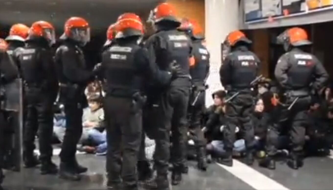 Agentes de la Ertzaintza desalojan el hall de la facultad