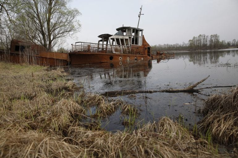 FOTOGALERÍA | Una vieja lancha abandonada en el canal del río Pripyat en la Reserva Radioecológica Estatal dentro de la zona de exclusión a 30 kilómetros del reactor nuclear de Chernóbil