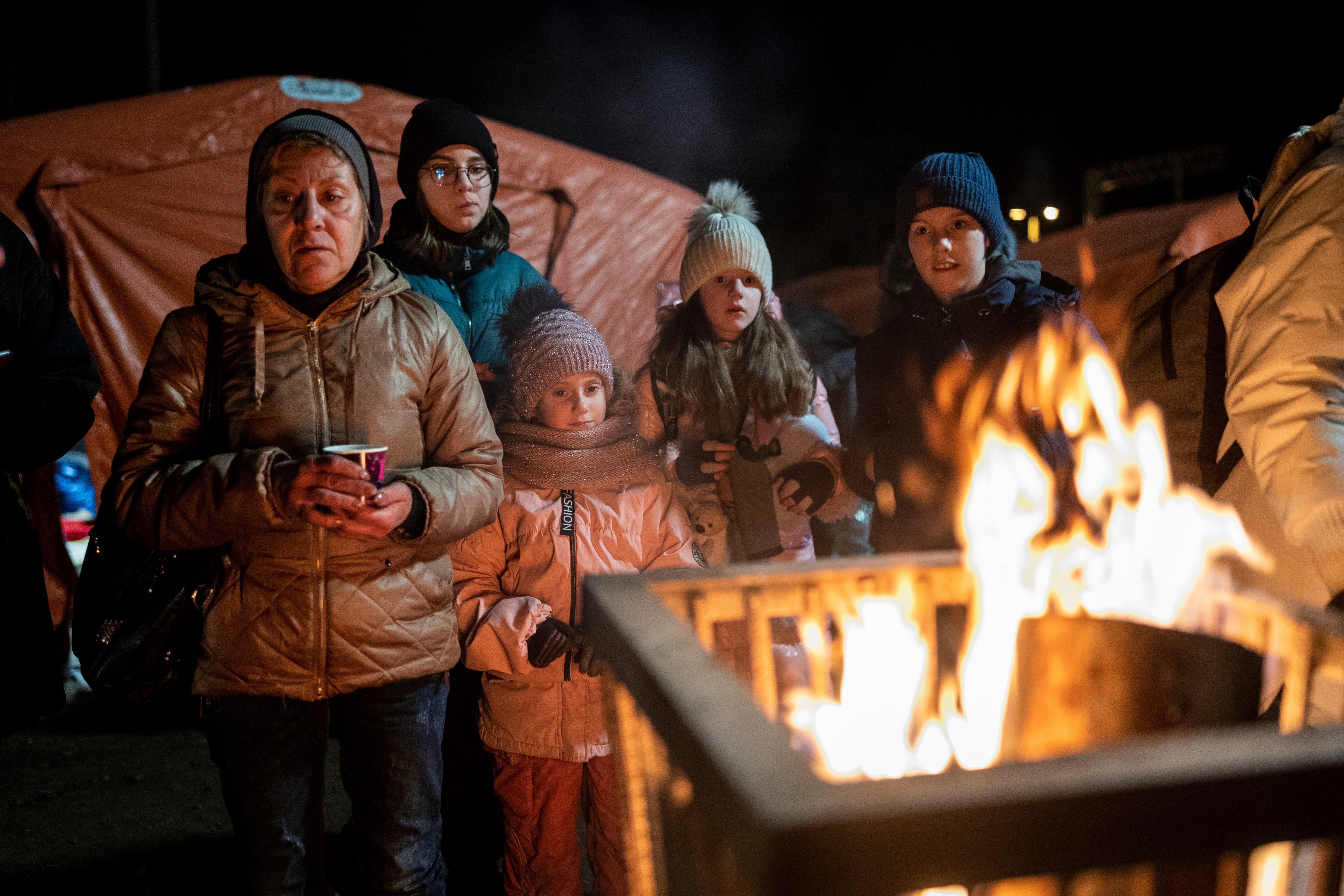 Un grupo de refugiados ucranianos se protegen del frío en la localidad polaca de Medyka, en la frontera con Ucrania