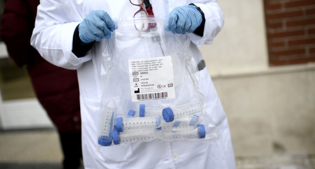 Un sanitario con tubos de ensayo durante la realización de tests de RT-PCR