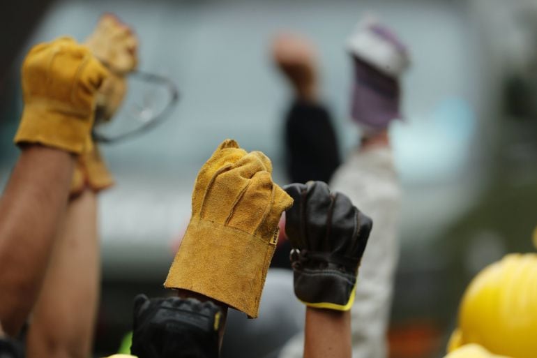 Brigadas de rescatistas y voluntarios levantan sus manos para pedir silencio absoluto mientras continúan escarbando de forma manual en las ruinas de una escuela 