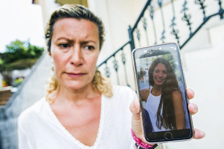 La madre de la chica desaparecida muestra su foto.