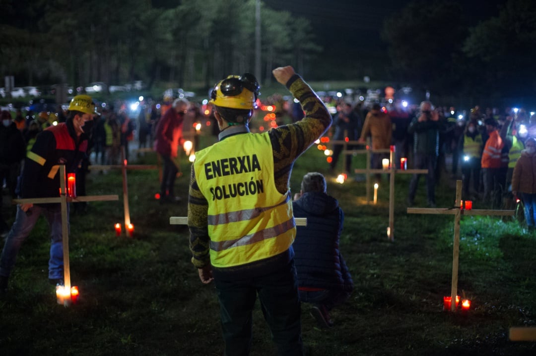 Un trabajador levanta el brazo como signo de protesta durante un velatorio nocturno simbólico convocado por la fábrica de Alcoa, en San Cibrao.