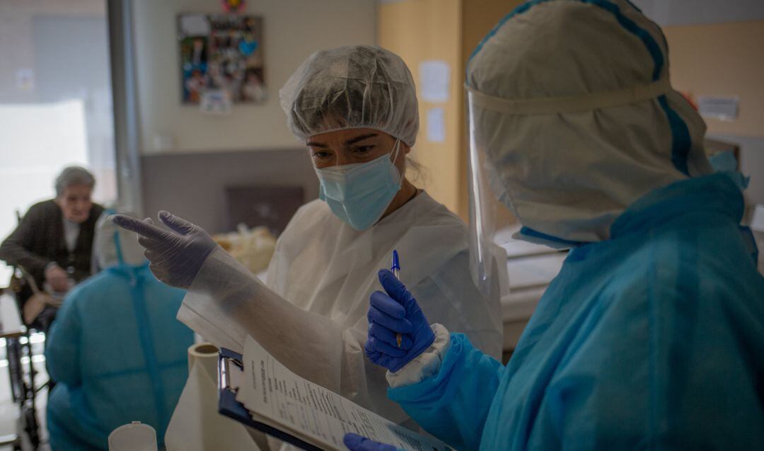 Dos personas realizan test rápidos de Covid-19 a miembros de una residencia de ancianos.