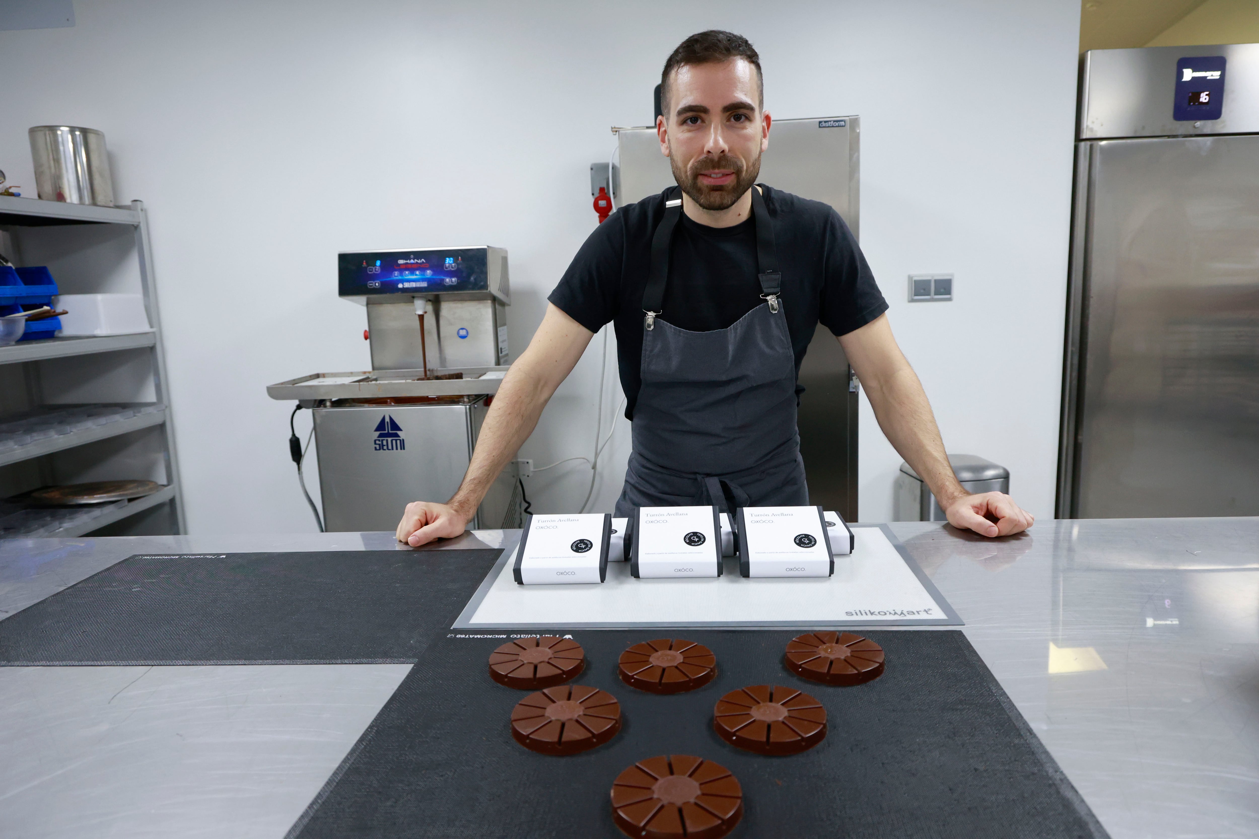 Pontedeume, 12/12/2024.-Un año después de su estreno, la marca de chocolates Oxóco, que los elabora con productos como alga percebe o eucalipto, se lanza al mercado de los turrones con una apuesta por recuperar los sabores tradicionales del producto protagonista de la Navidad; en la imagen, Tomás Rodríguez en su obrador dando los últimos toques a unos turrones. EFE/ Kiko Delgado.