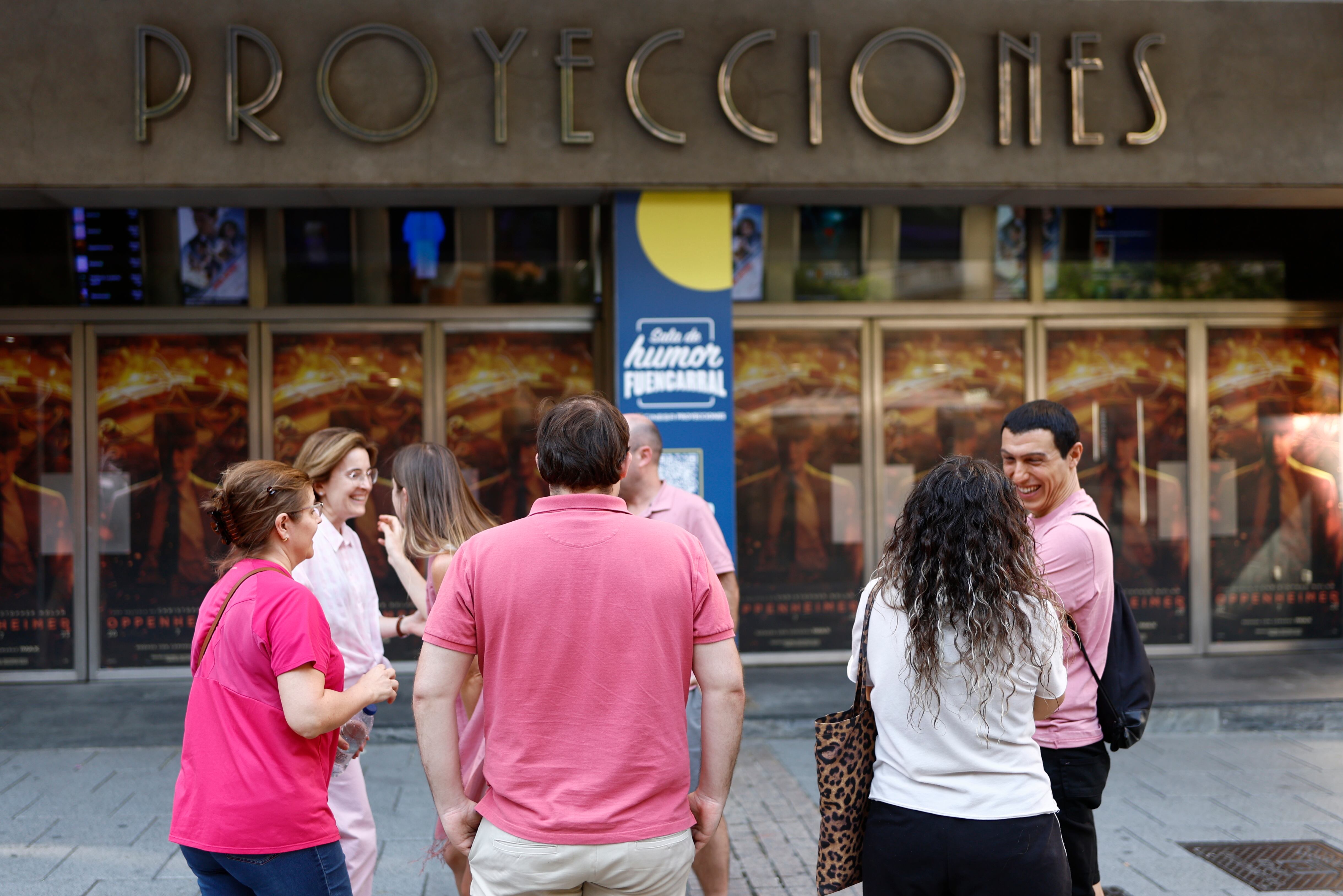 Varias personas lucen atuendos rosas momentos antes de asistir a la proyección de la película Barbie, en Madrid.