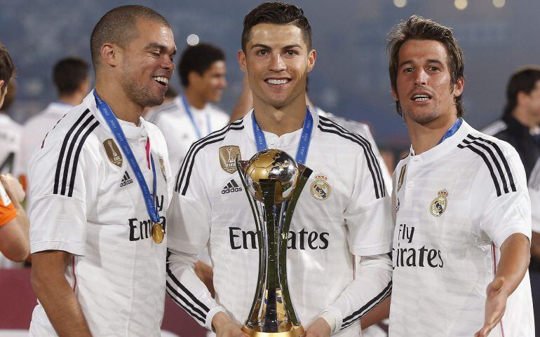 Los portugueses del Real Madrid (i-d) Pepe, Cristiano Ronaldo y Coentrao posan con el trofeo de campeones del Mundial de Clubes