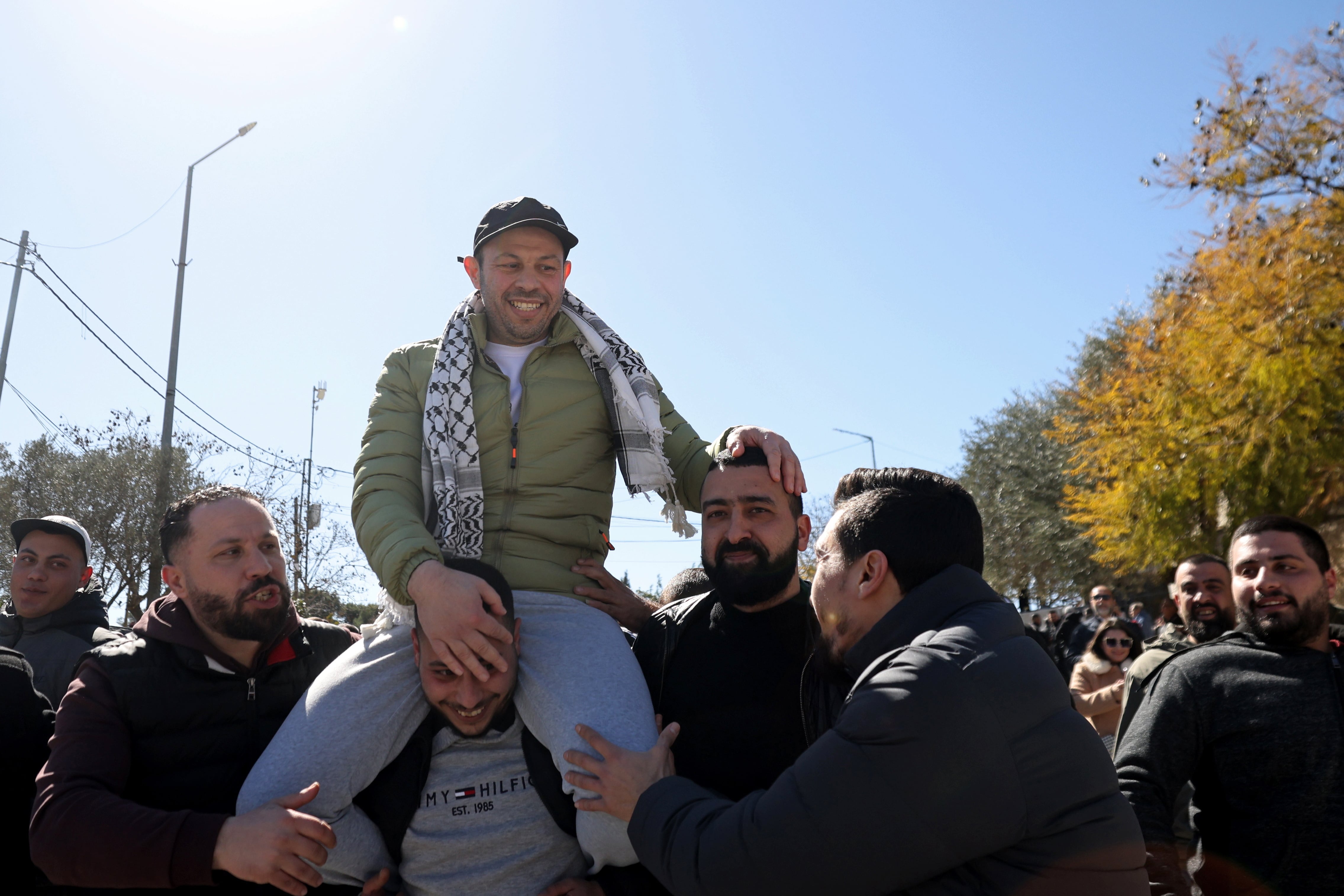 Un hombre palestino es recibido por familiares y amigos tras su excarcelación en Ramallah, Cisjordania, este sábado, en el marco del sexto intercambio del alto el fuego. EFE/EPA/ALAA BADARNEH