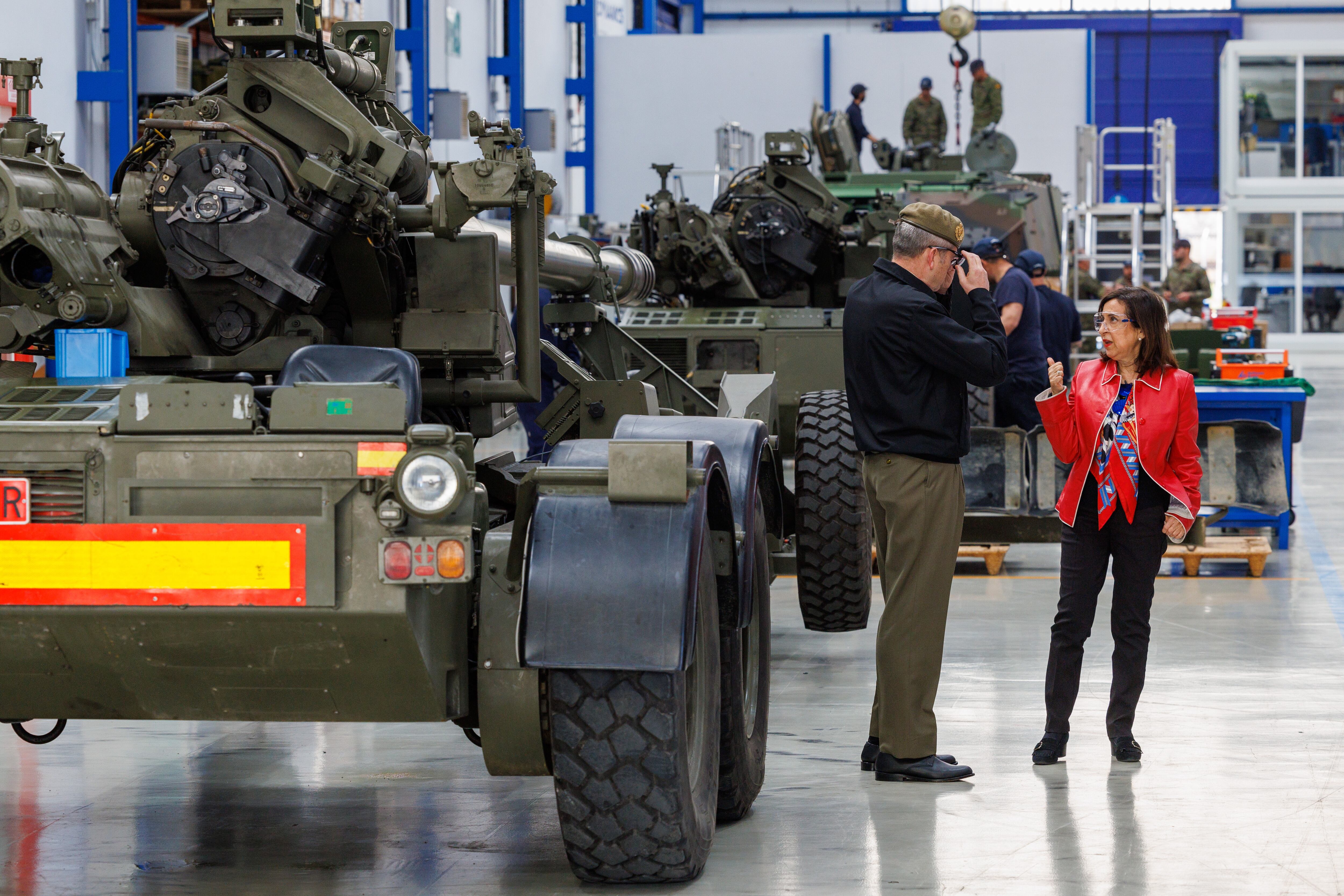 La ministra de Defensa, Margarita Robles (d), en las instalaciones de Santa Bárbara Sistemas en Alcalá de Guadaíra (Sevilla) junto a uno de los seis tanques Leopard 2A4 que están siendo reparados y puestos a punto para que España los transfiera a Ucrania de inmediato. EFE/ Julio Muñoz