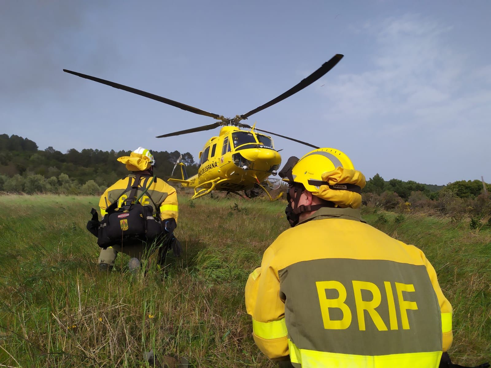 Trabajadores de la BRIF junto al helicóptero