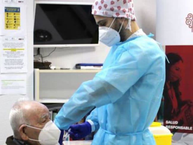 Un enfermero vacuna a un anciano