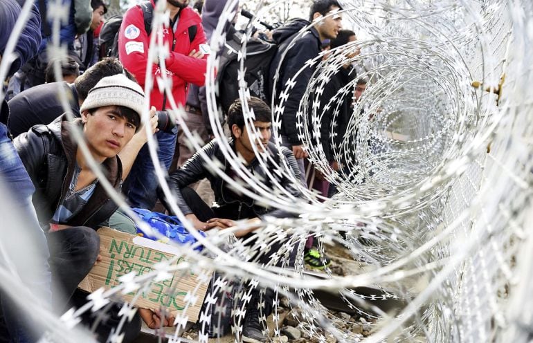 Refugiados junto al alambre de púas colocado en la frontera entre Grecia y Macedonia. 