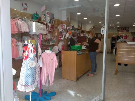 Dependientes y una clienta, en una tienda de ropa de niños en Carolinas.