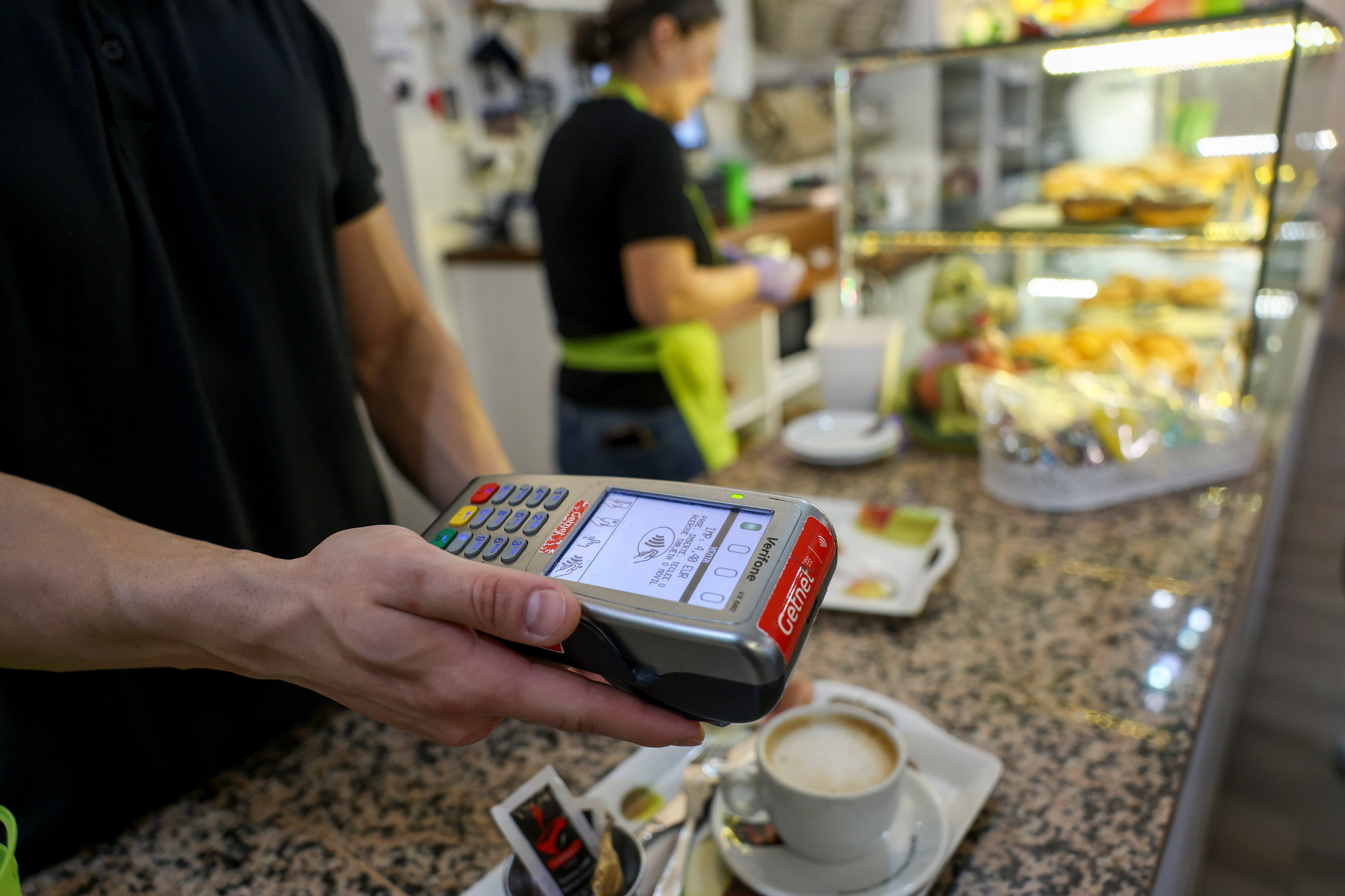 Un dependiente de hostelería cobra con un datáfono este viernes en Toledo. EFE/ Ismael Herrero