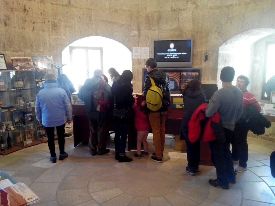 Un grupo de personas recibe información en la Oficina de Turismo de Cuéllar