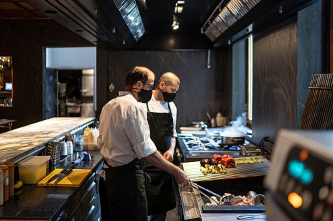 Cocineros de un restaurante con mascarilla 