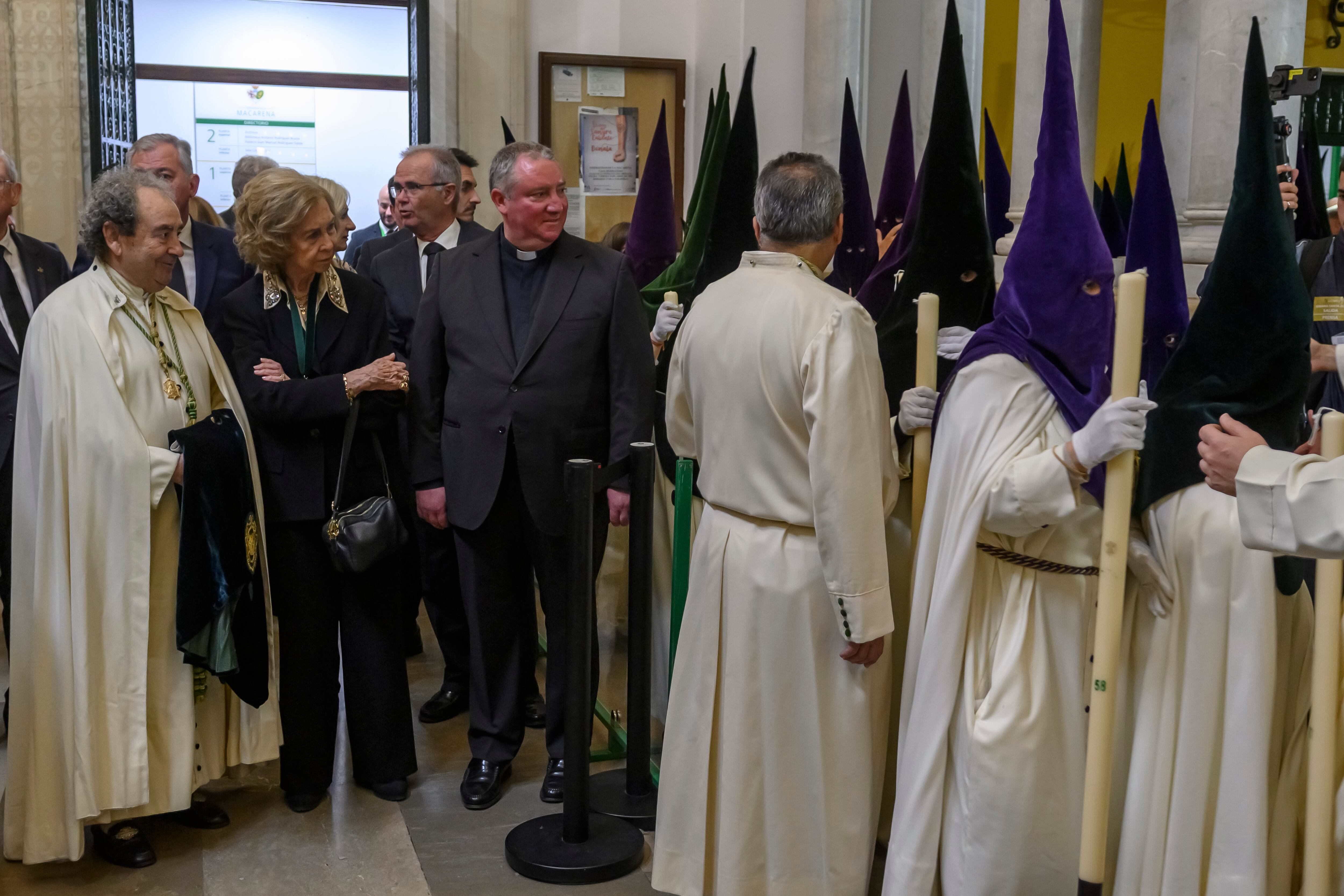 La Reina Sofía junto al Hermano Mayor de la Hermandad de La Macarena, José Antonio Fernández (i), ha presenciado la salida de la cofradía este jueves, en Sevilla (España). EFE/ Raúl Caro