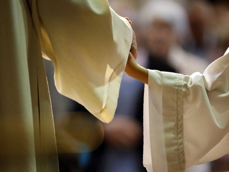 Imagen de archivo de un sacerdote y un monaguillo