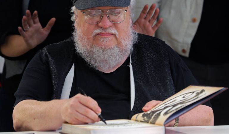 George R.R. Martin firmando un ejemplar de la saga &#039;Canción de hielo y fuego&#039;.