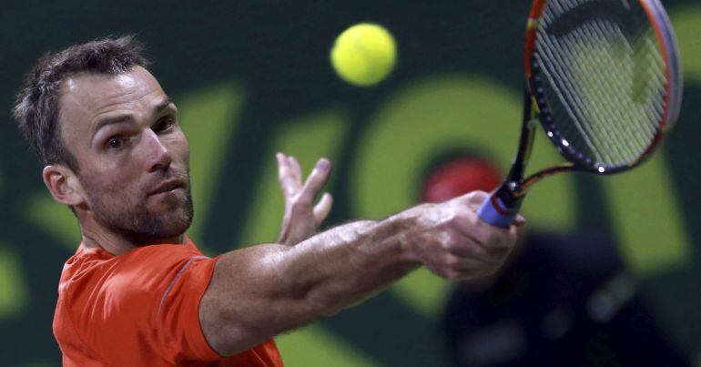 El tenista croata Ivo Karlovic devuelve la pelota al serbio Novak Djokovic durante el partido de cuartos de final del torneo de Doha, Catar hoy 8 de enero de 201