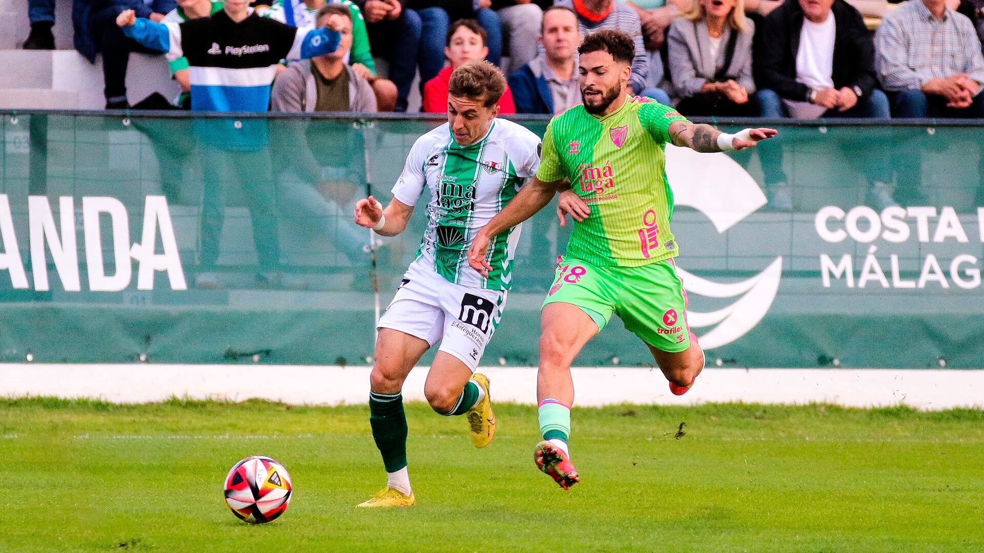 Loren Burón disputando la pelota con Dani Sánchez en el último Antequera-Málaga en El Maulí